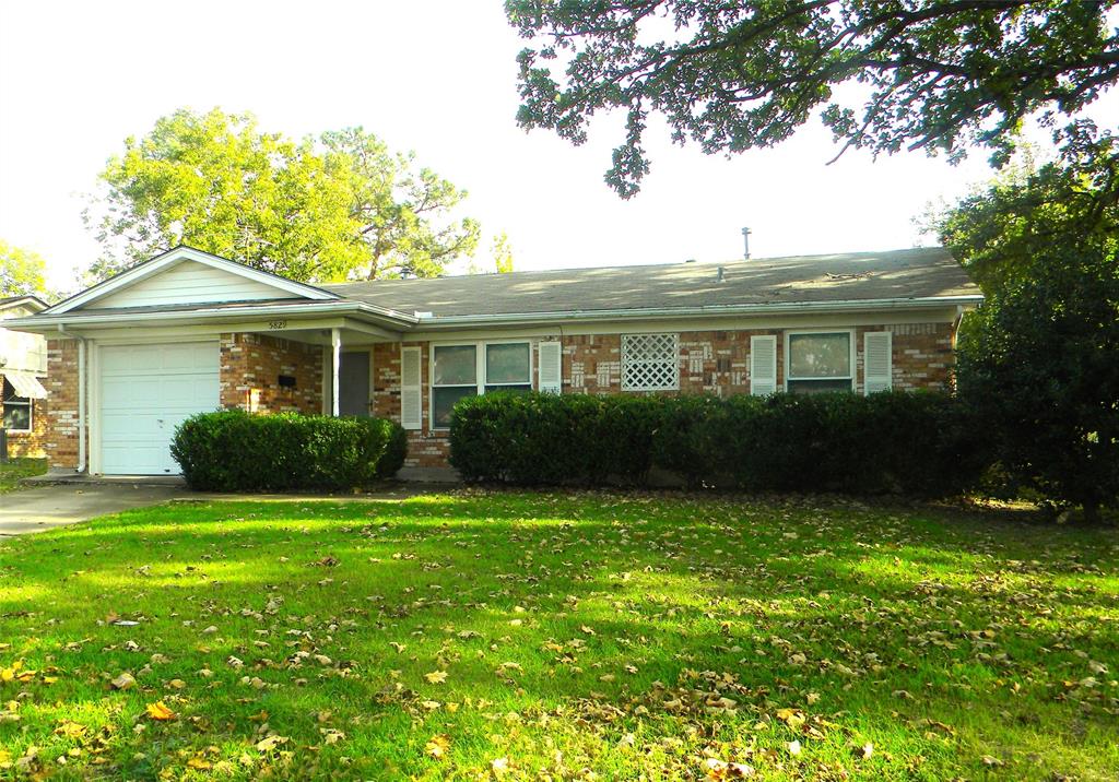 a front view of a house with a garden and yard