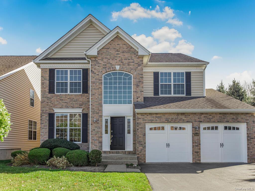 View of front facade with a front yard and a garage