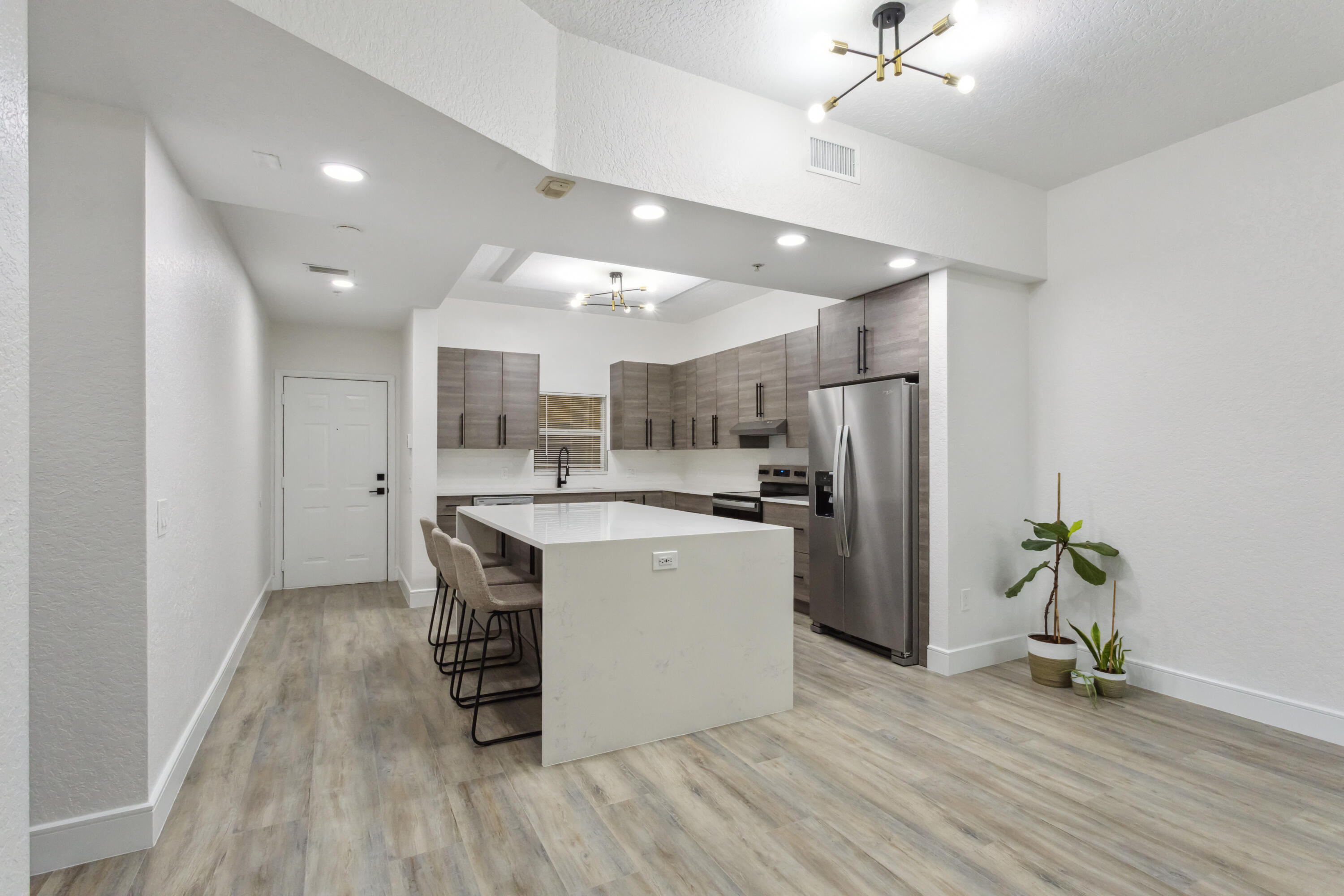 a kitchen with a refrigerator a sink and a stove top oven