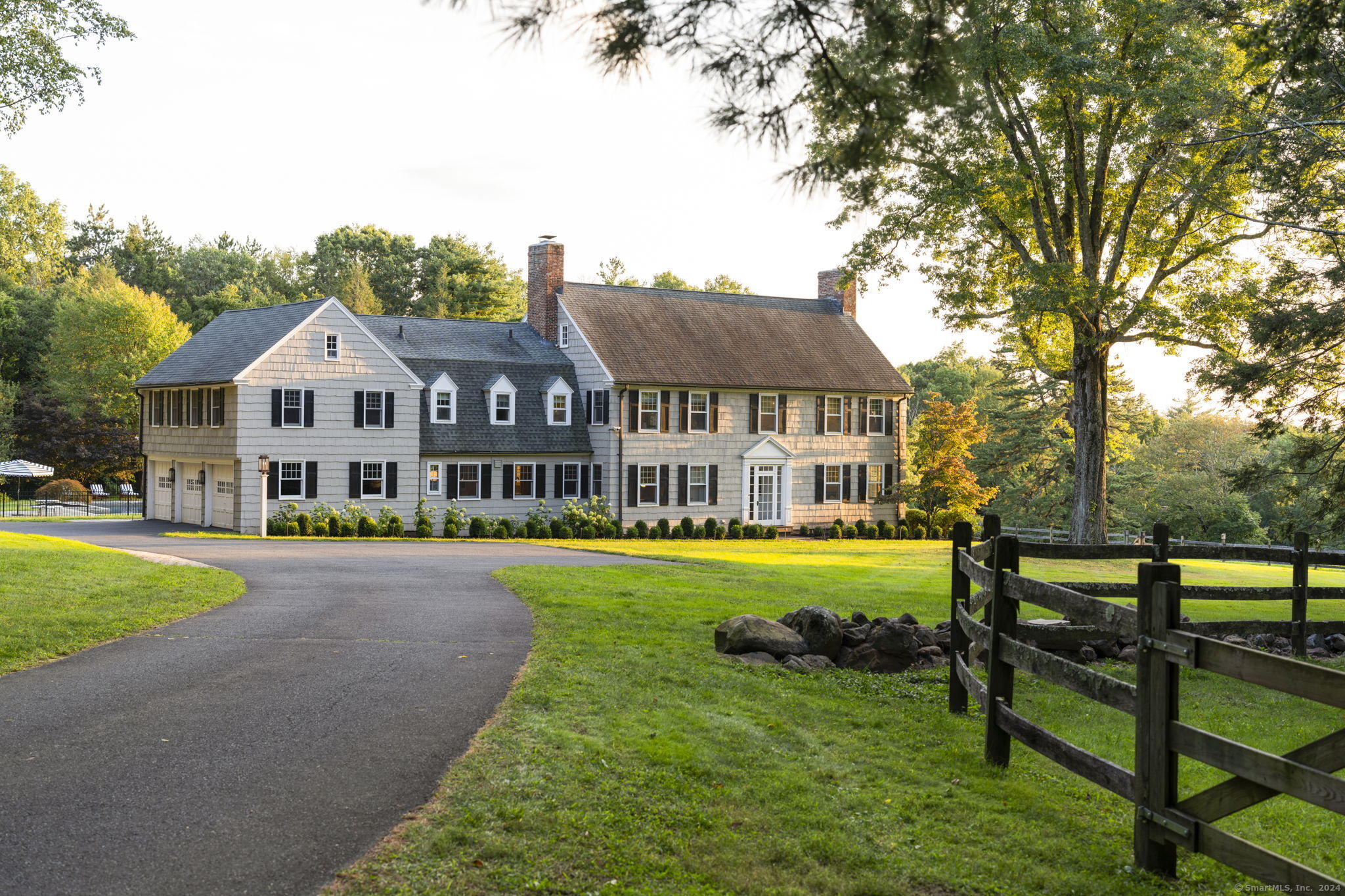 a front view of a house with garden and trees