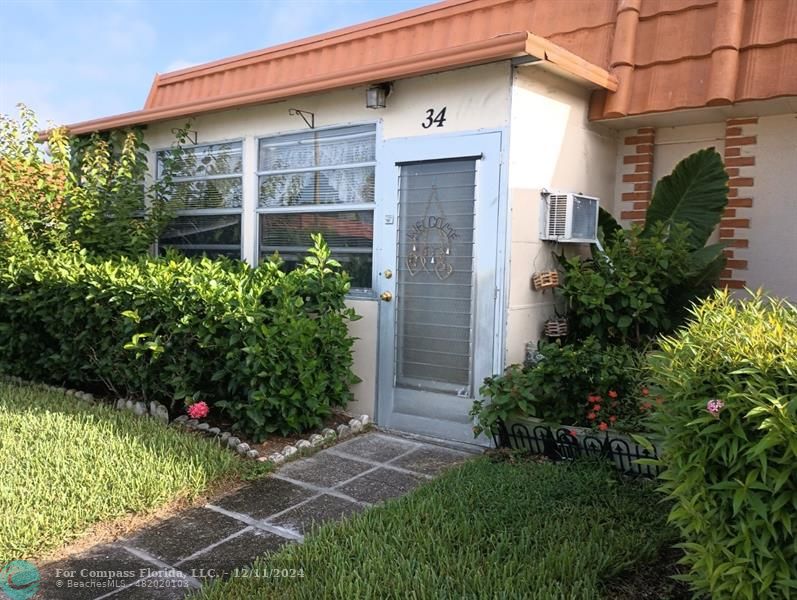 a front view of a house with plants