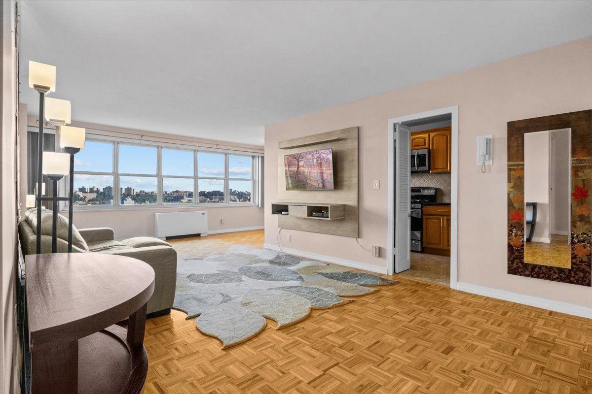 a living room with furniture a rug and kitchen view