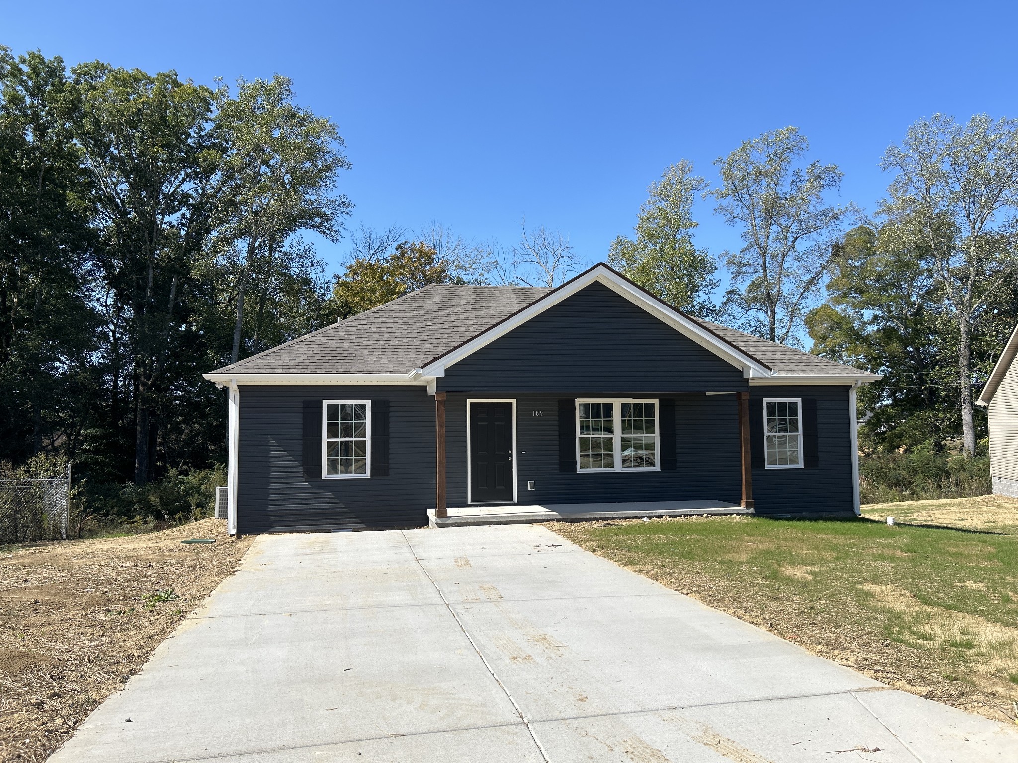 a front view of house with yard and trees in the background