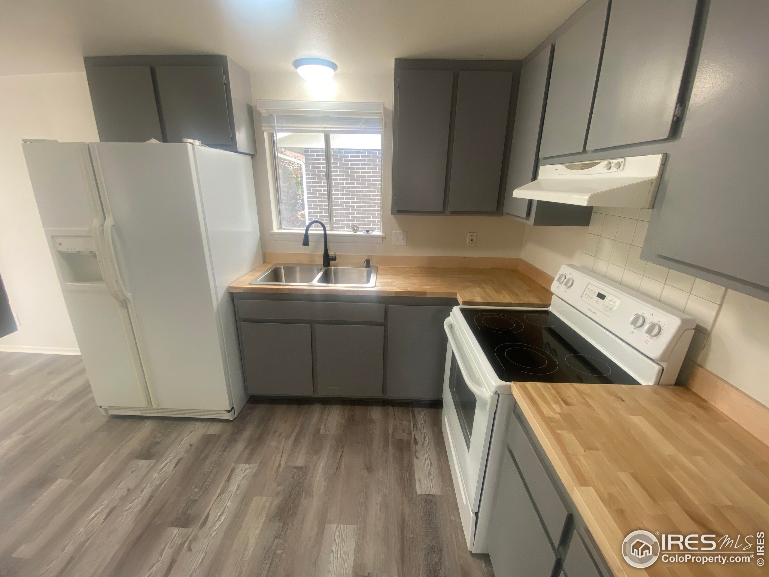 a kitchen with a sink a stove a refrigerator and cabinets