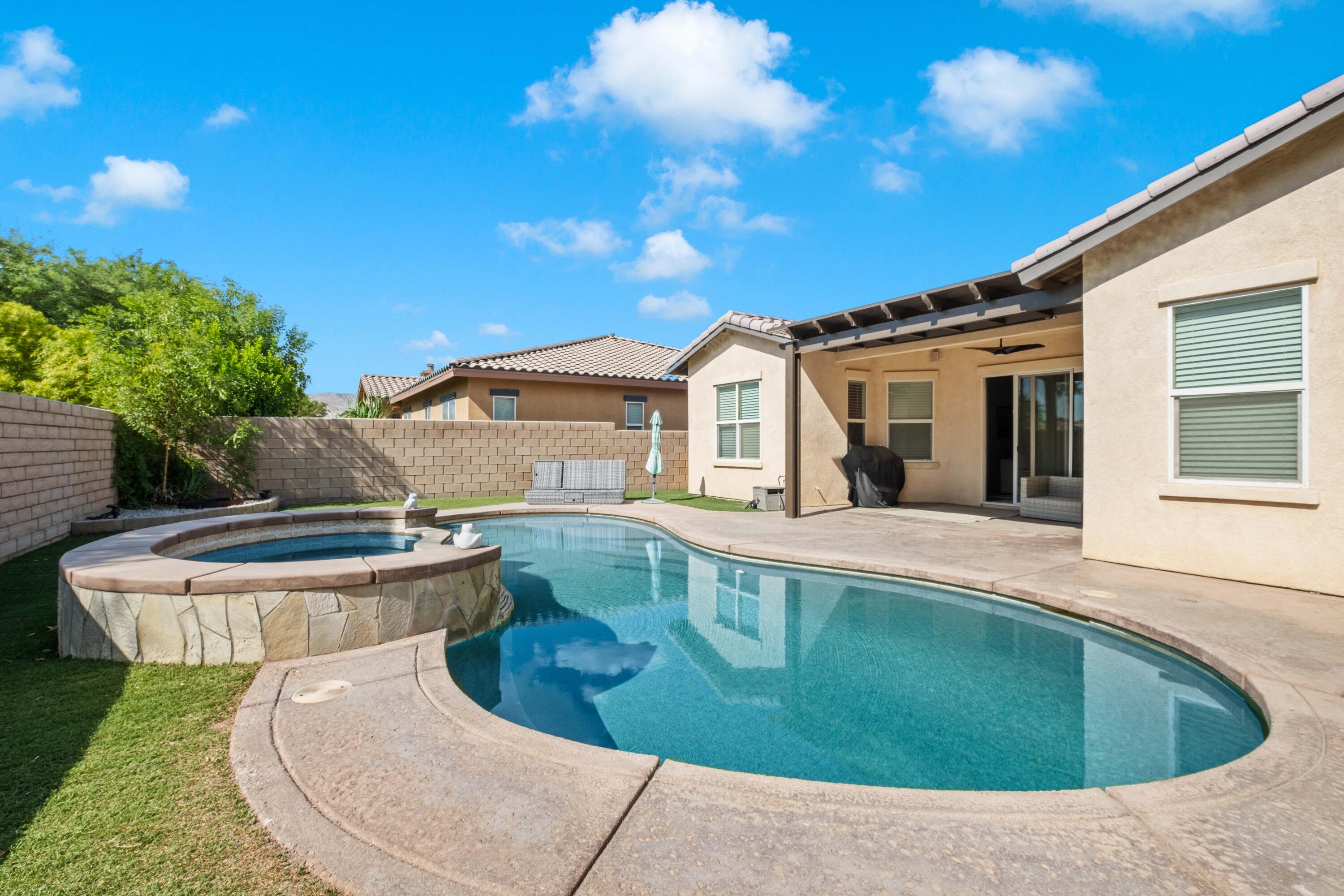 a view of a house with pool fire pit and chairs