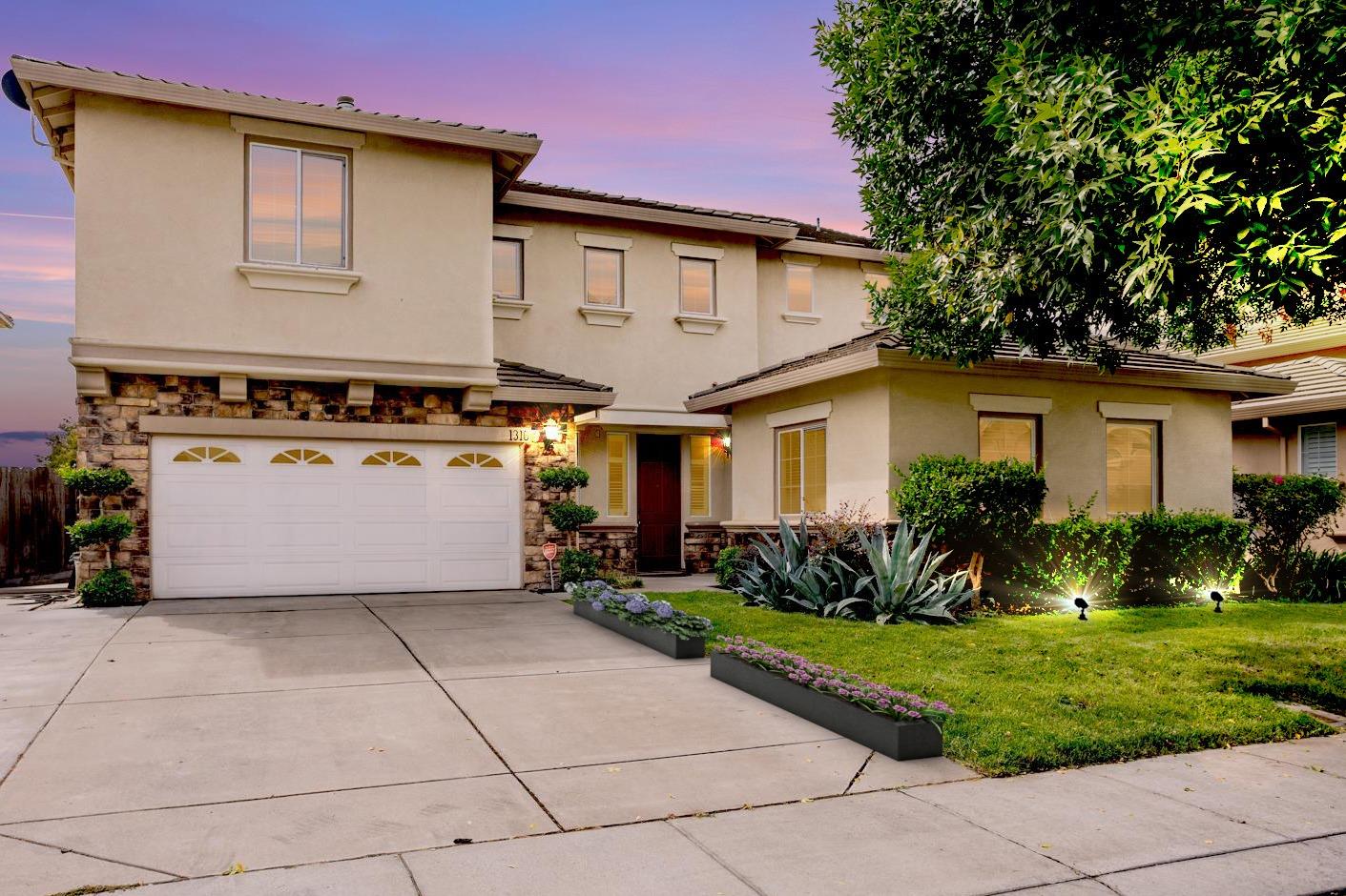 a front view of a house with a yard and a garage