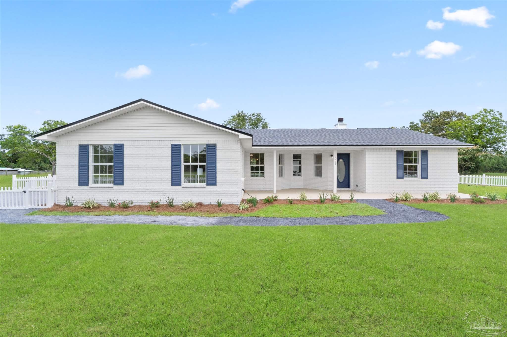 a front view of house with a garden and yard