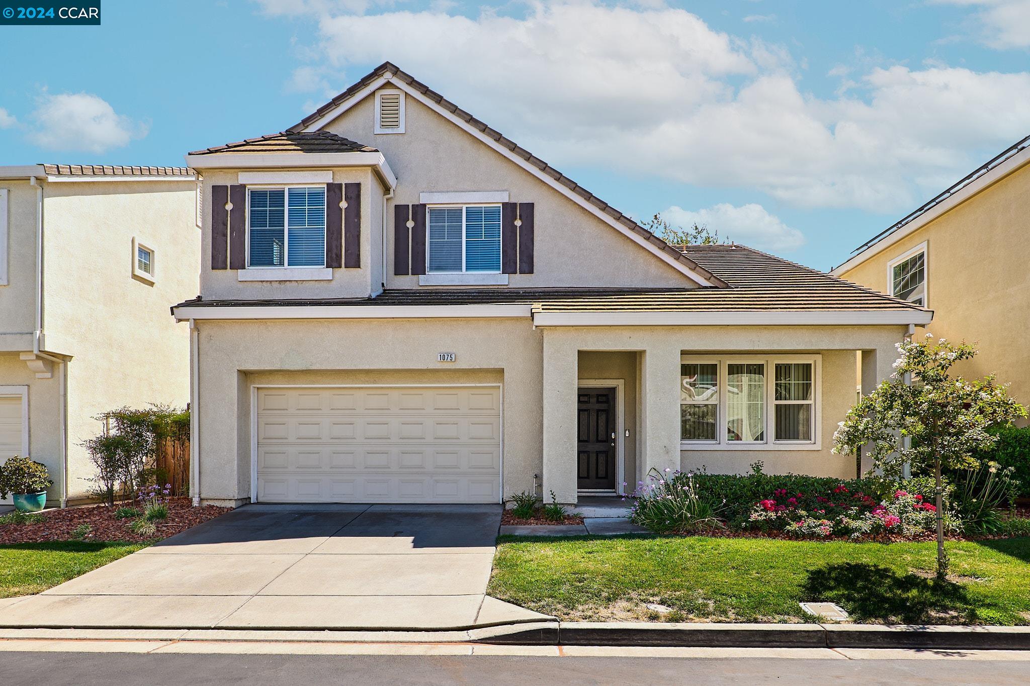 a front view of a house with a yard and garage