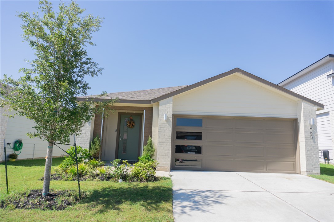 Single story home with a garage and a front yard