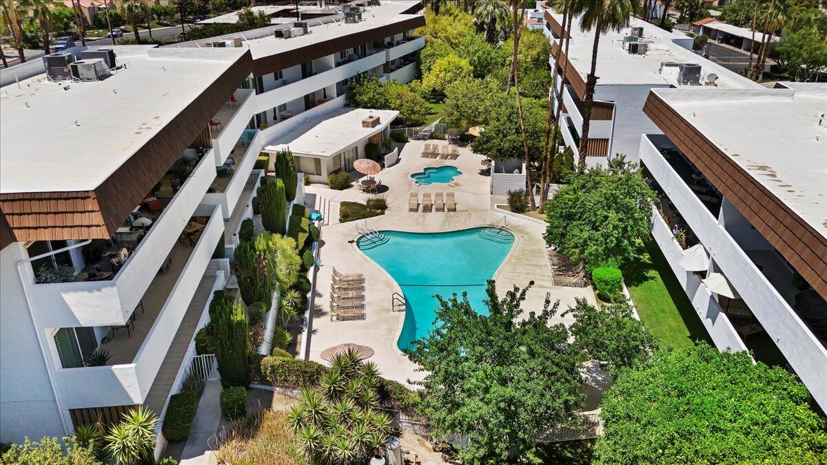 an aerial view of residential houses with outdoor space and trees