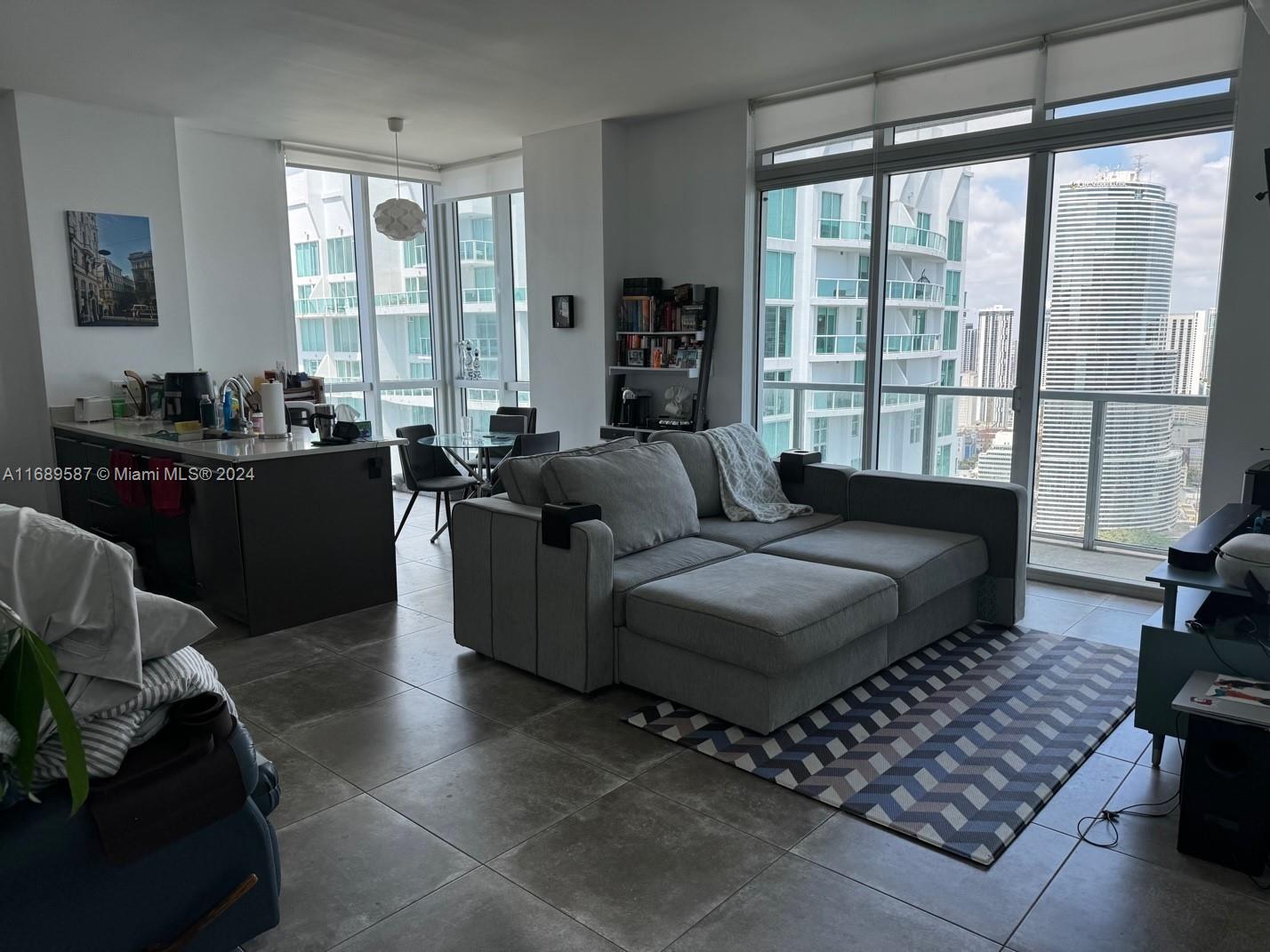 a living room with furniture and a floor to ceiling window