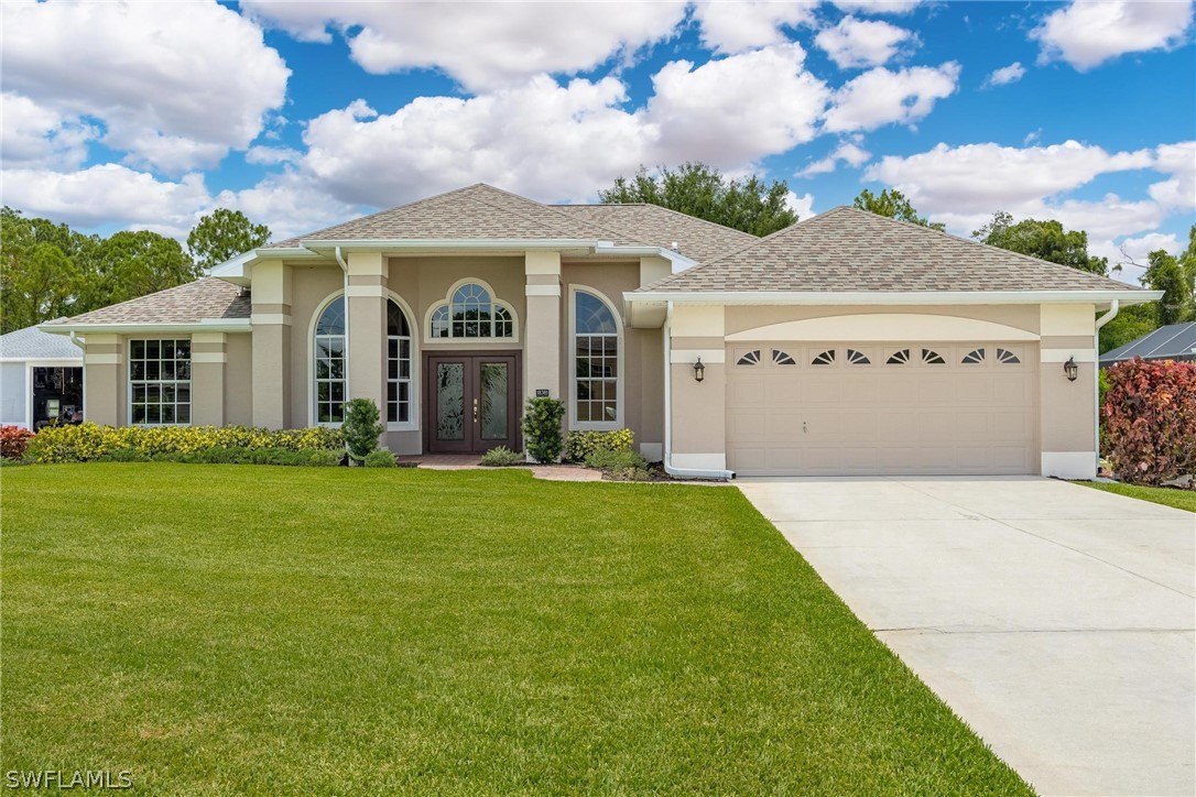 a front view of a house with a garden and yard