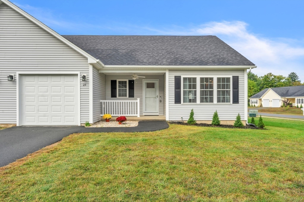 a view of a house with a patio and a yard