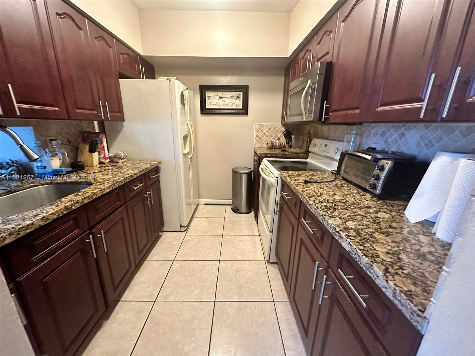 a kitchen with a stove top oven sink and cabinets