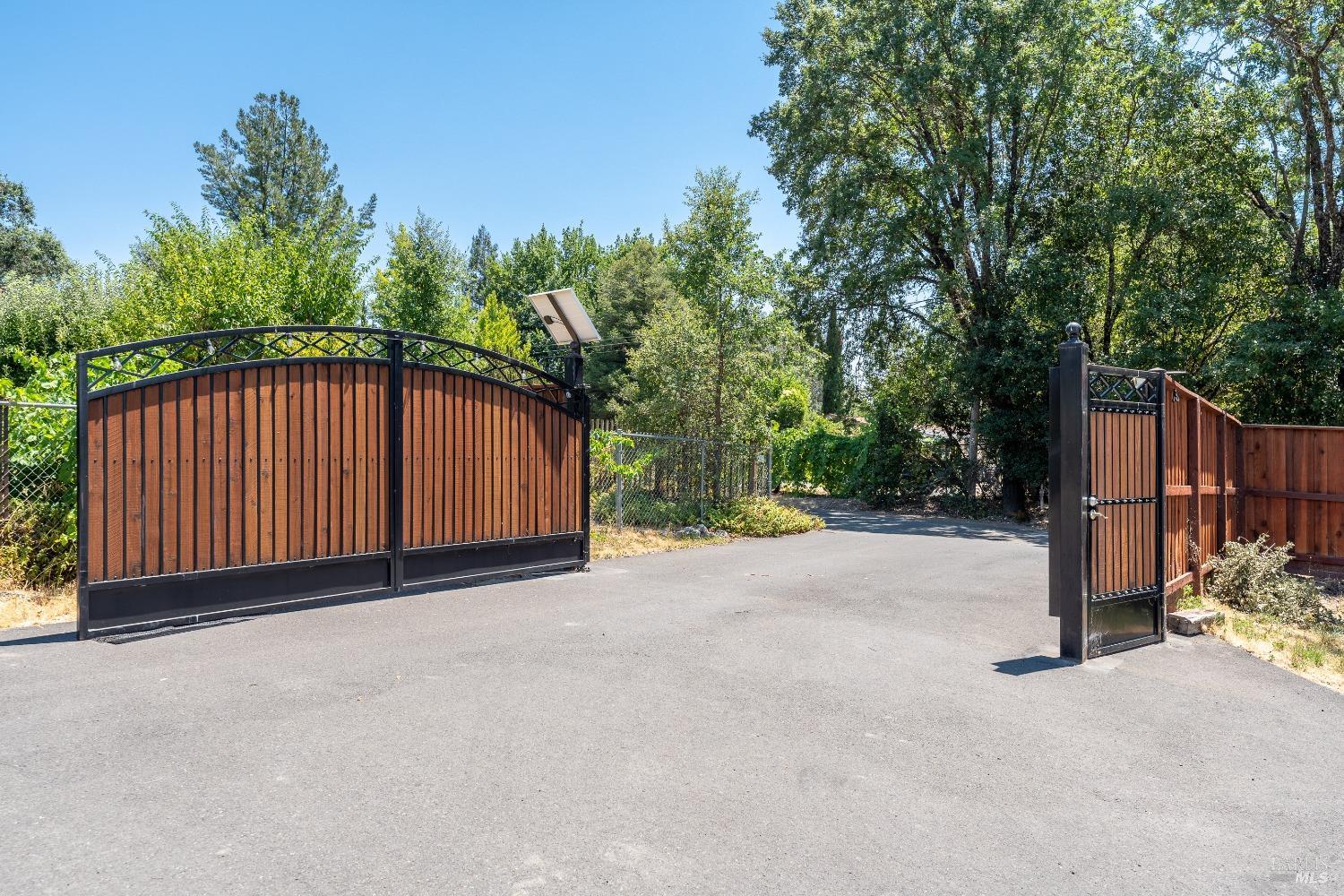 a view of a backyard with wooden fence and trees