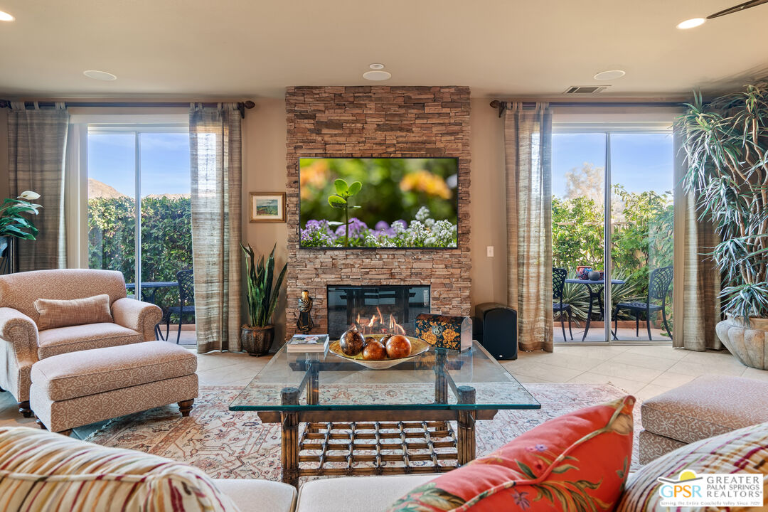 a living room with furniture a fireplace and a floor to ceiling window