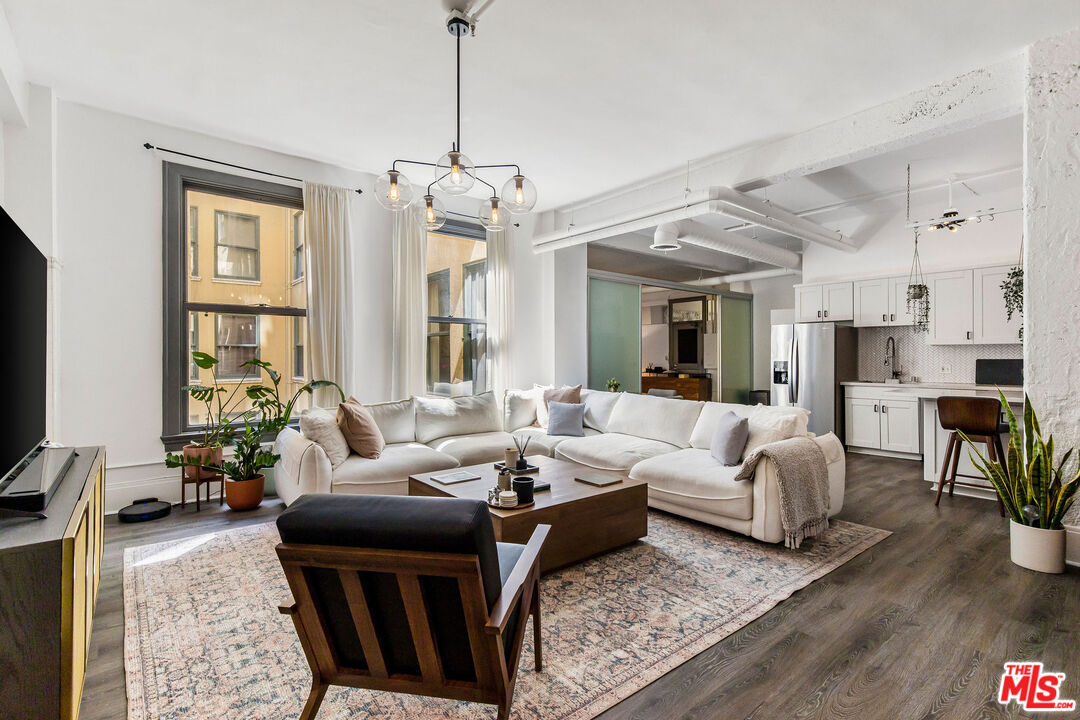 a living room with furniture wooden floor and a flat screen tv