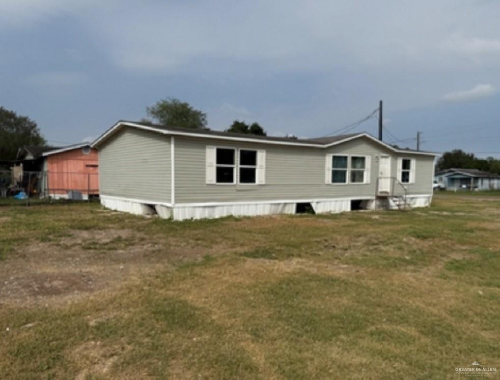 Back of property featuring a lawn