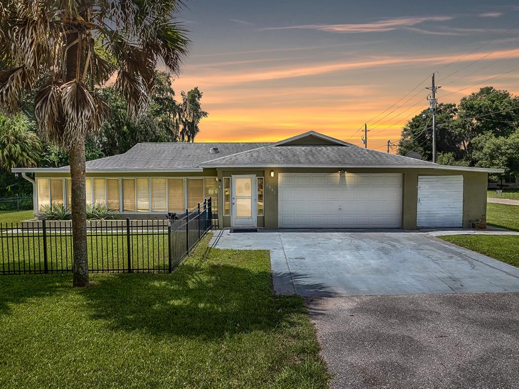 a view of a house with a yard and fence