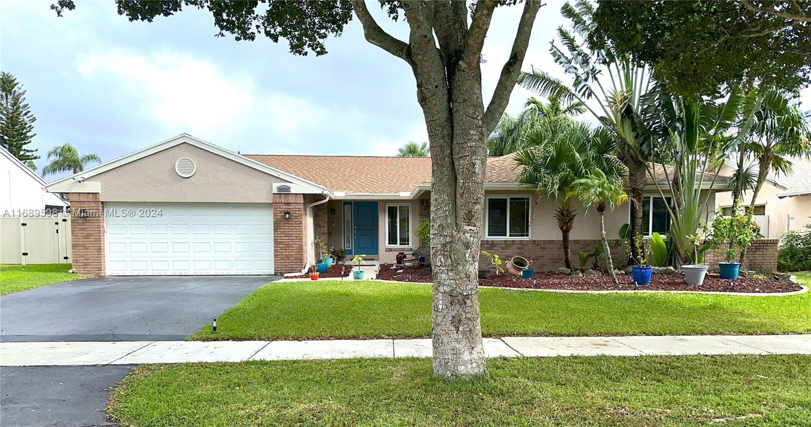 a front view of a house with a yard and trees