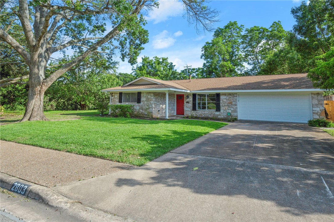 a front view of a house with a yard and trees