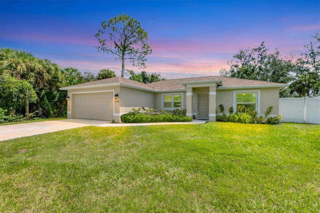 a view of a house with backyard and garden