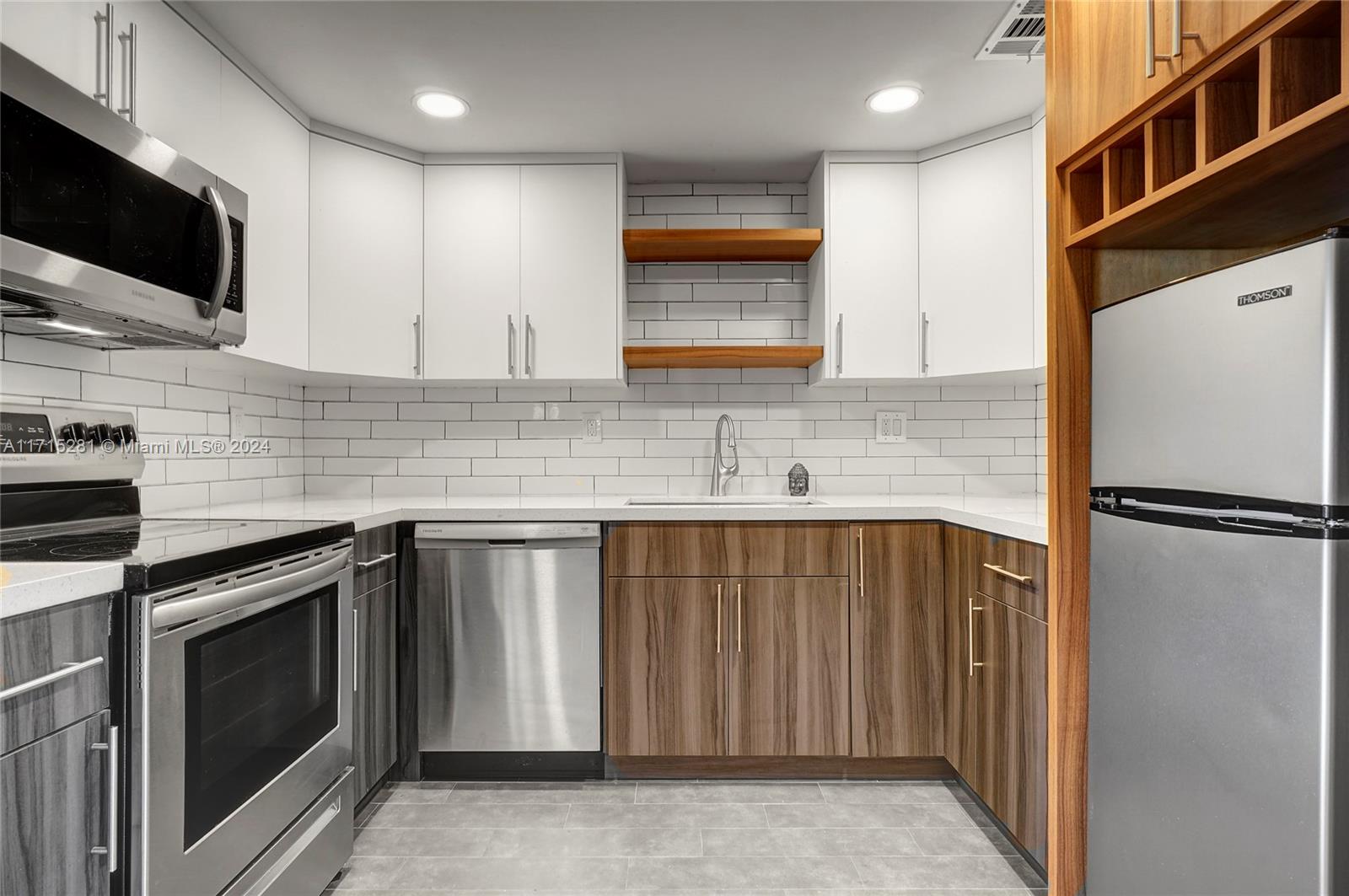 a kitchen with stainless steel appliances a refrigerator sink and microwave