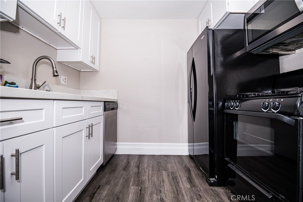 a kitchen with a sink a refrigerator and wooden floor