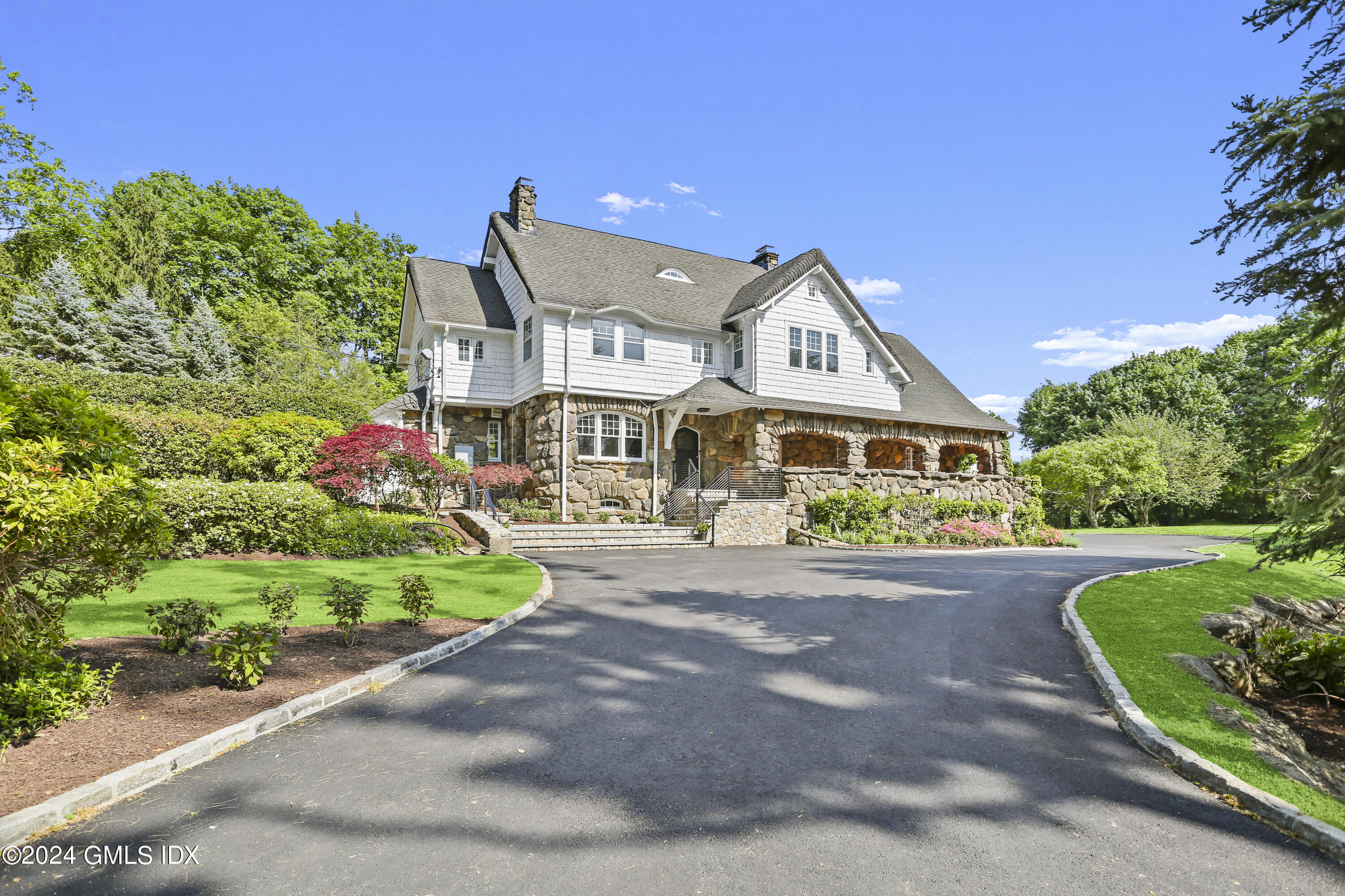 a front view of a house with a yard and potted plants