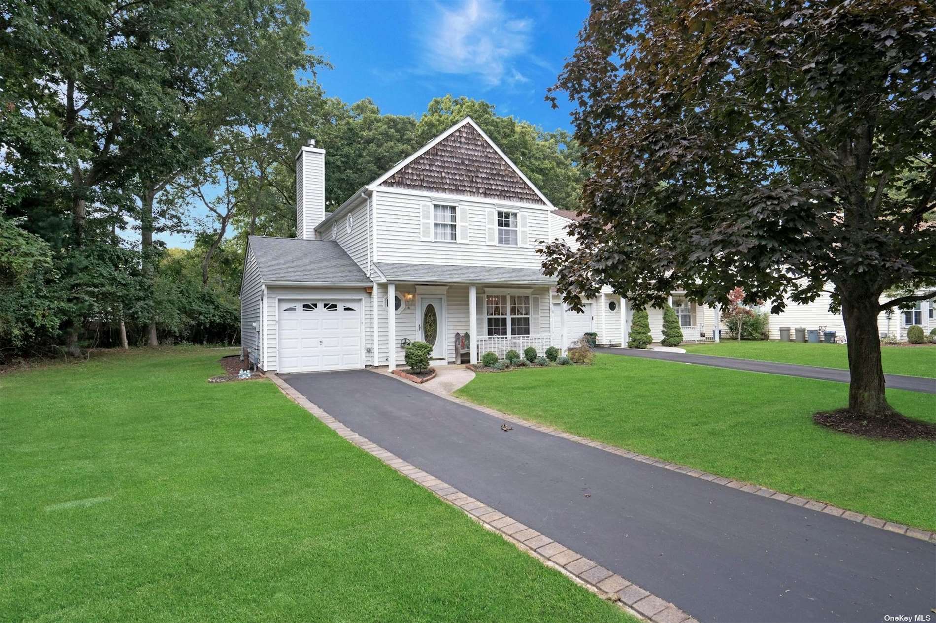 a front view of a house with a yard and trees