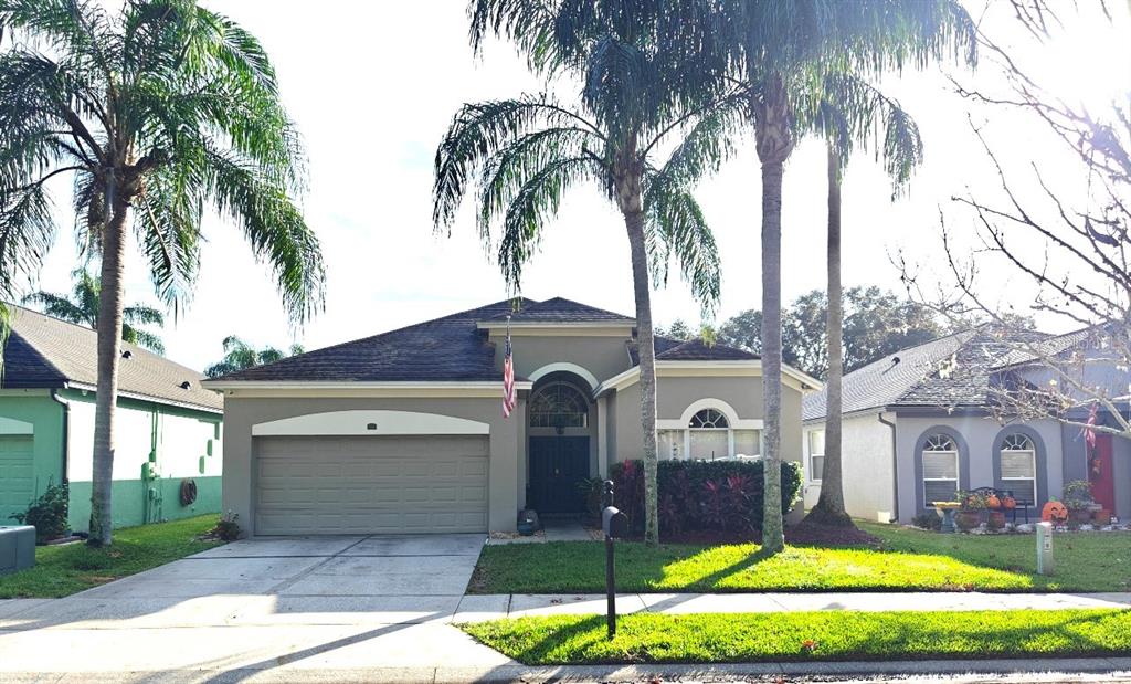 a front view of a house with a garden and palm trees