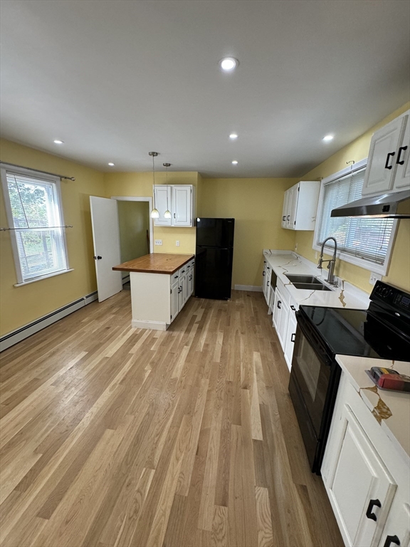 a kitchen with a sink a counter top space a stove and a window