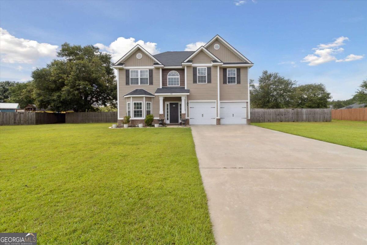 a view of a house with a big yard and large trees