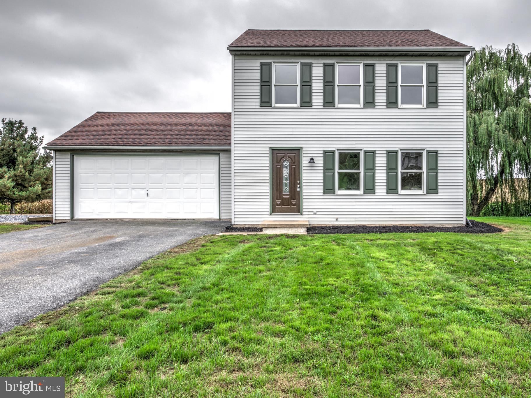 a view of a house with yard and garage