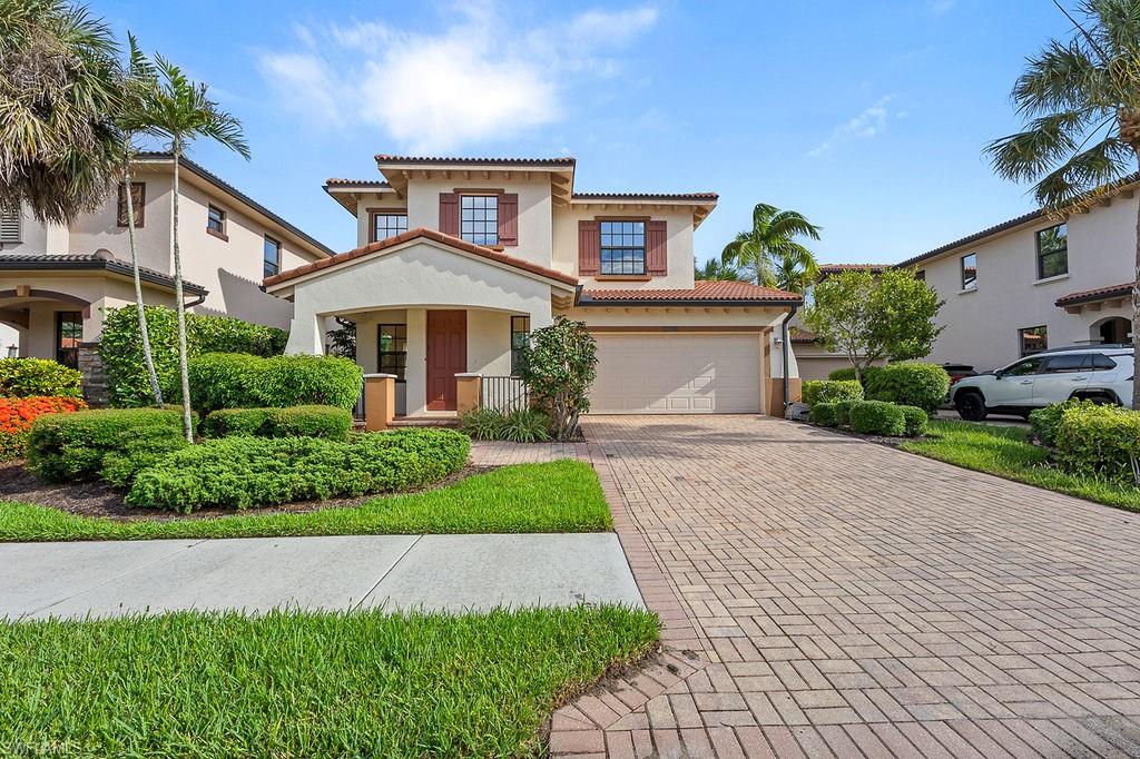 a front view of a house with a yard and potted plants