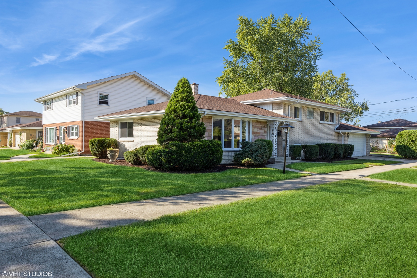 a front view of a house with a yard and trees