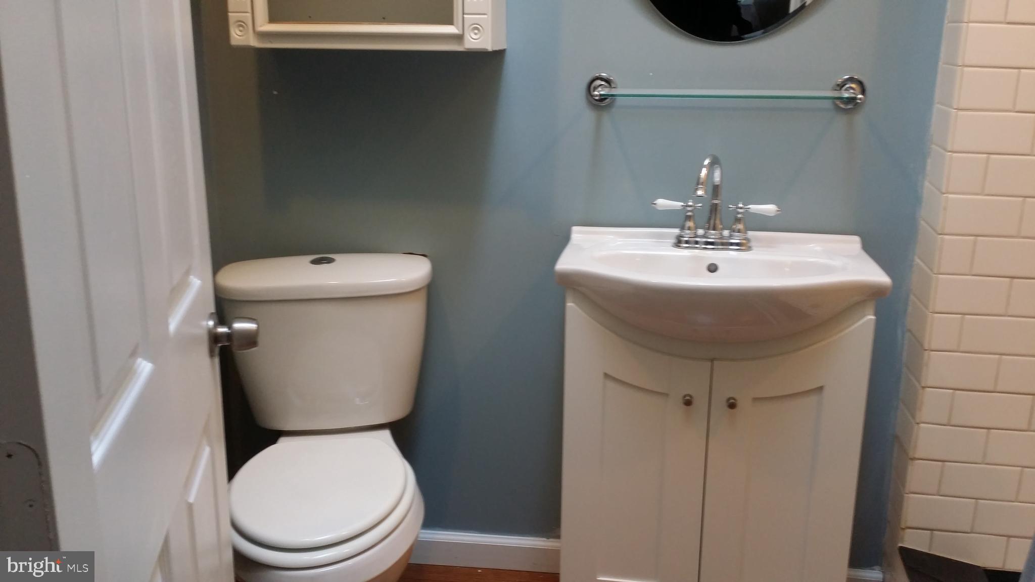 a bathroom with a toilet sink and mirror