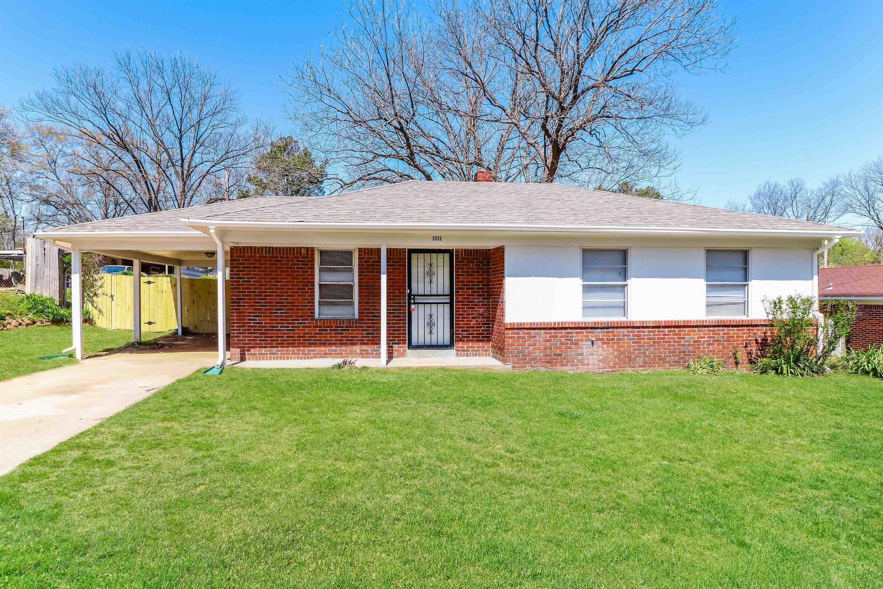 Ranch-style home with a carport and a front lawn