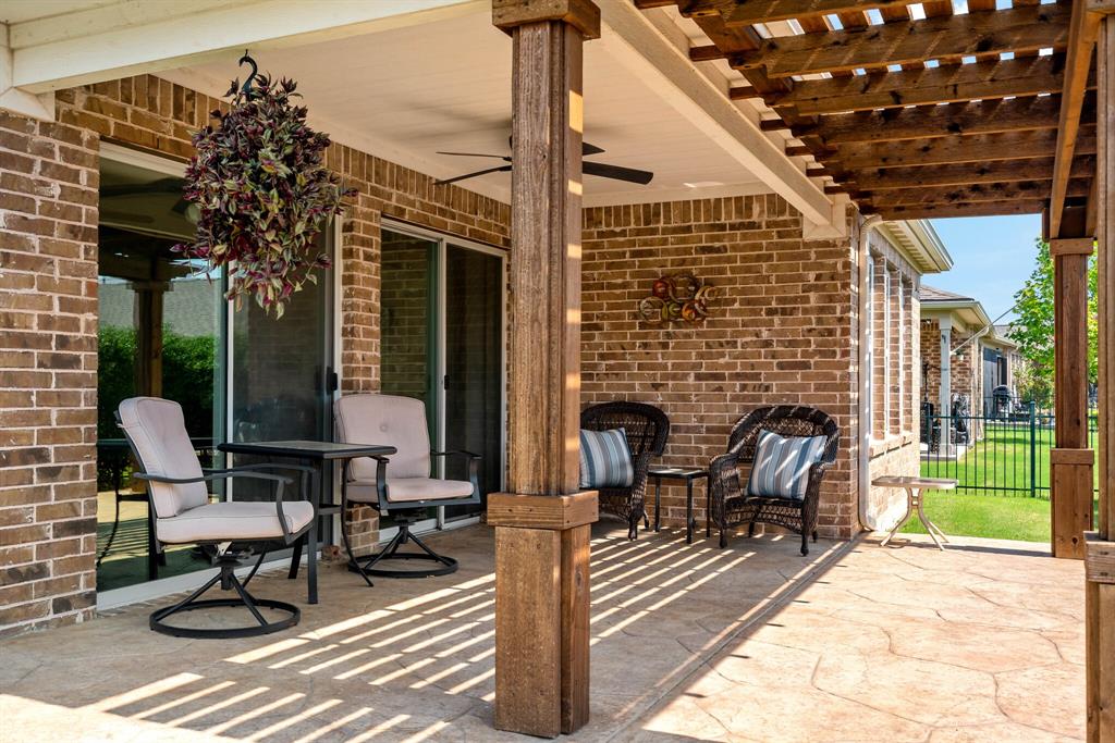 a view of a patio with table and chairs with wooden floor and fence