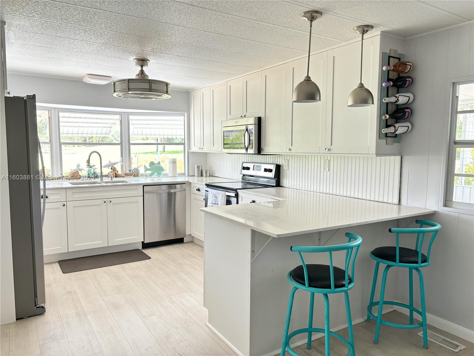 a kitchen with a sink a counter space appliances and cabinets