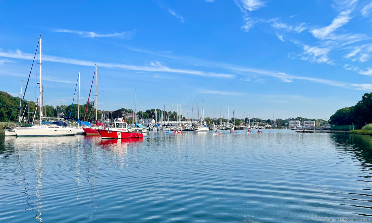 a view of ocean with boats and trees in the background