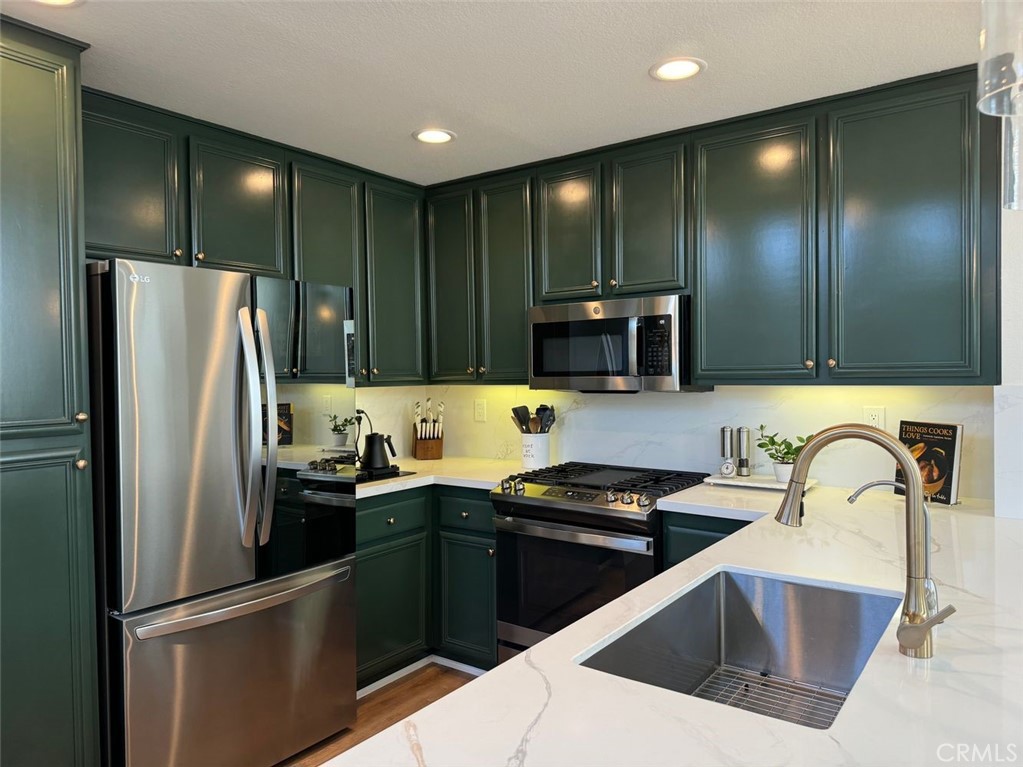 a kitchen with stainless steel appliances a refrigerator sink and microwave