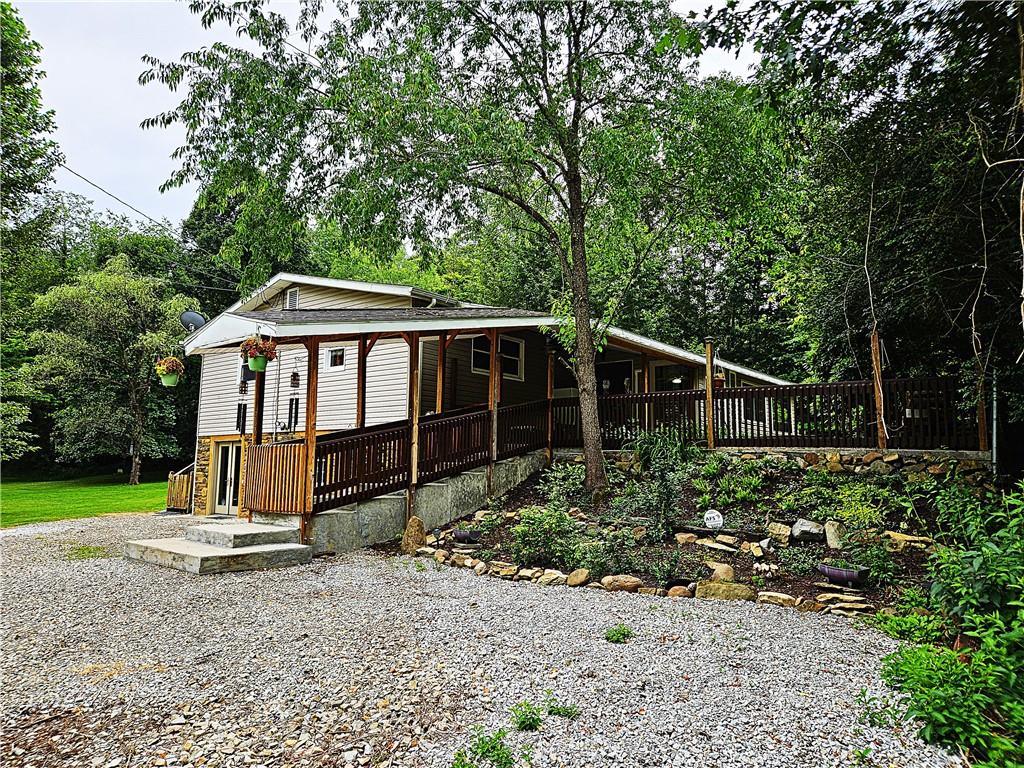 a view of a house with a yard and large trees