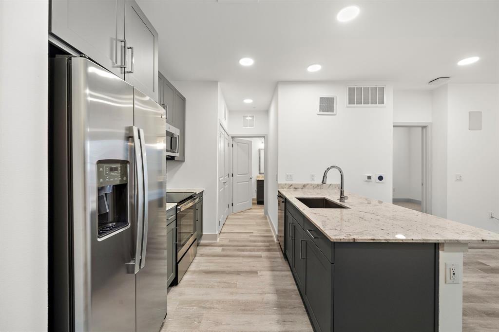 a kitchen with stainless steel appliances granite countertop a refrigerator and a sink