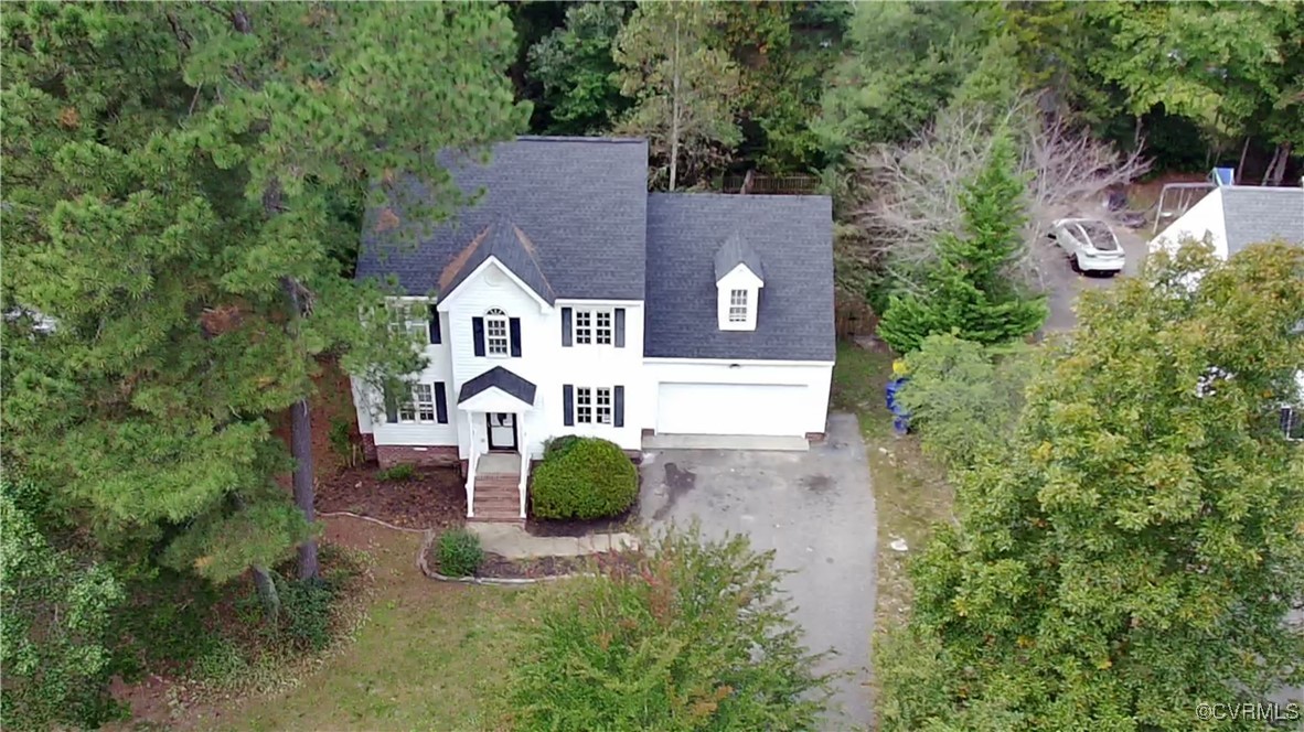 an aerial view of a house with yard and swimming pool