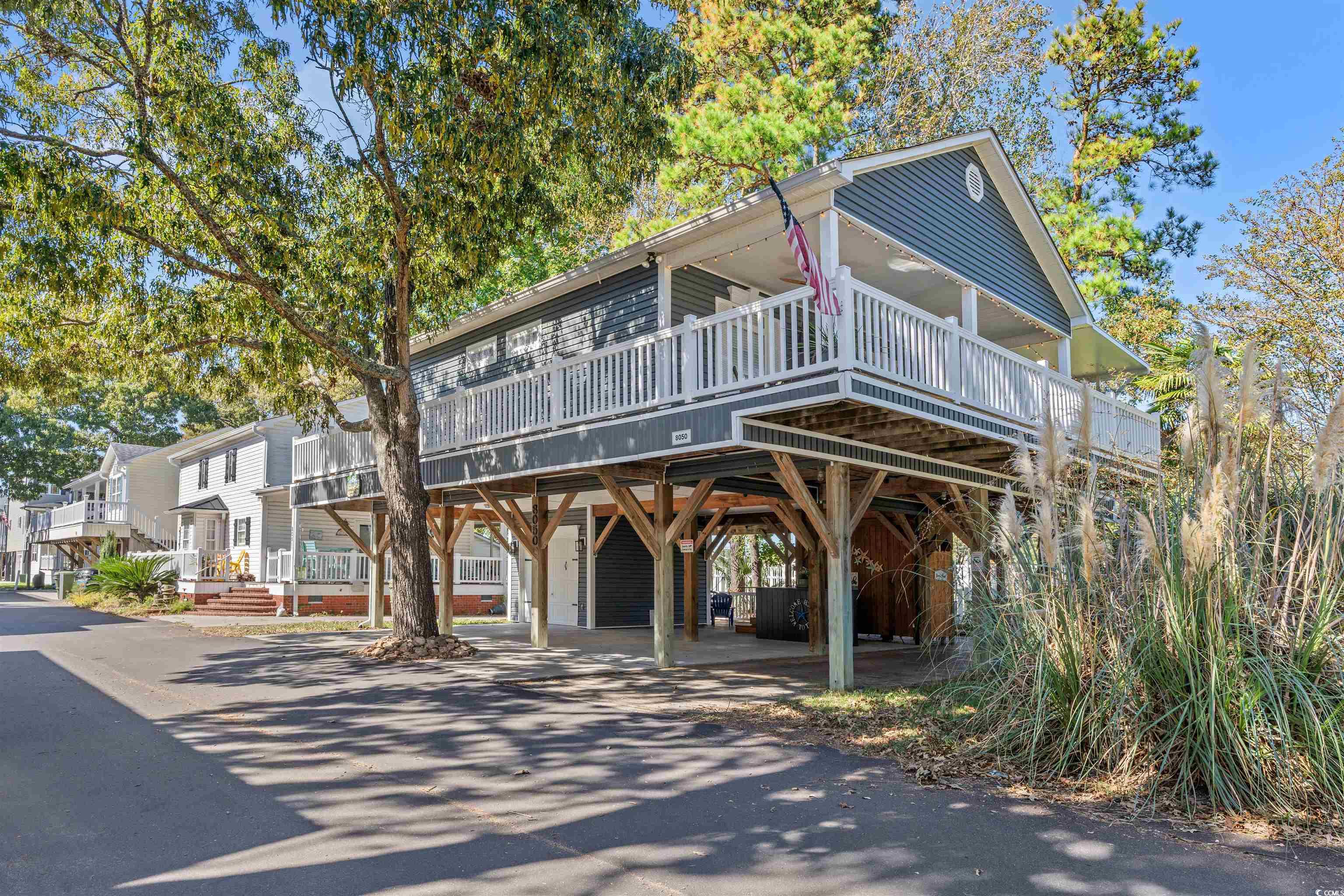 View of front of house featuring a wooden deck and