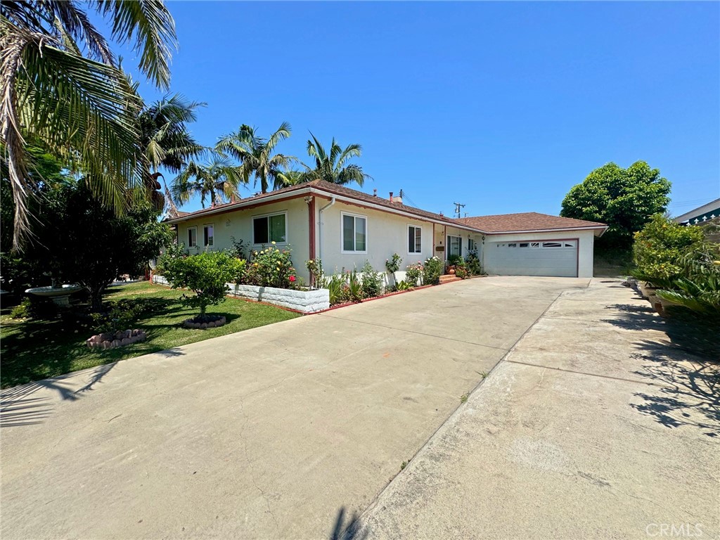 a front view of a house with a yard and potted plants