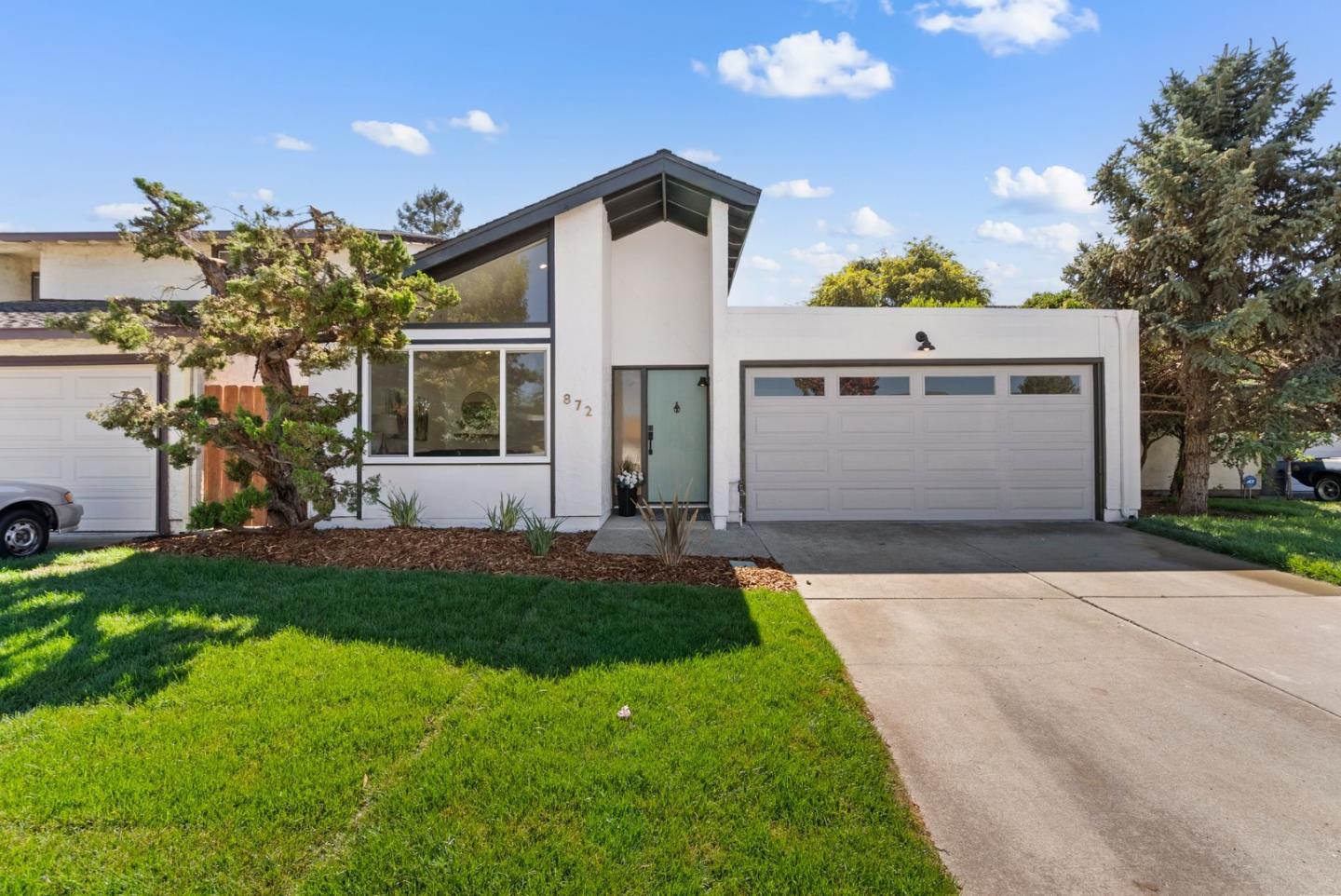 a front view of a house with a yard and garage