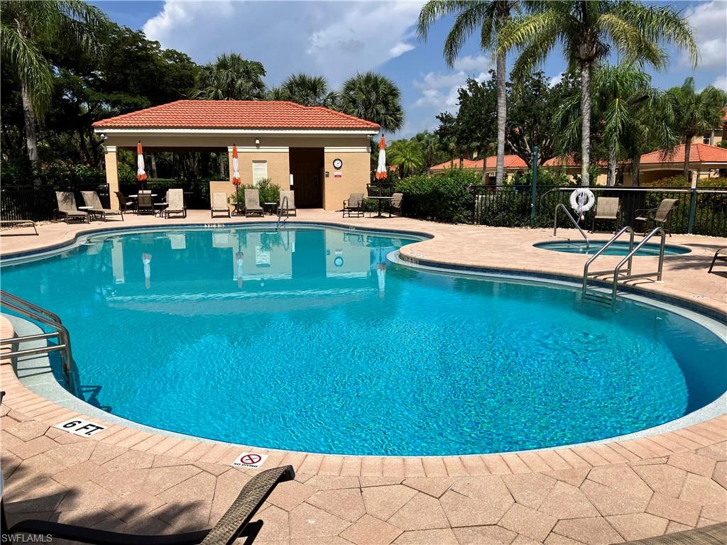 a view of a swimming pool with a table and chairs under an umbrella