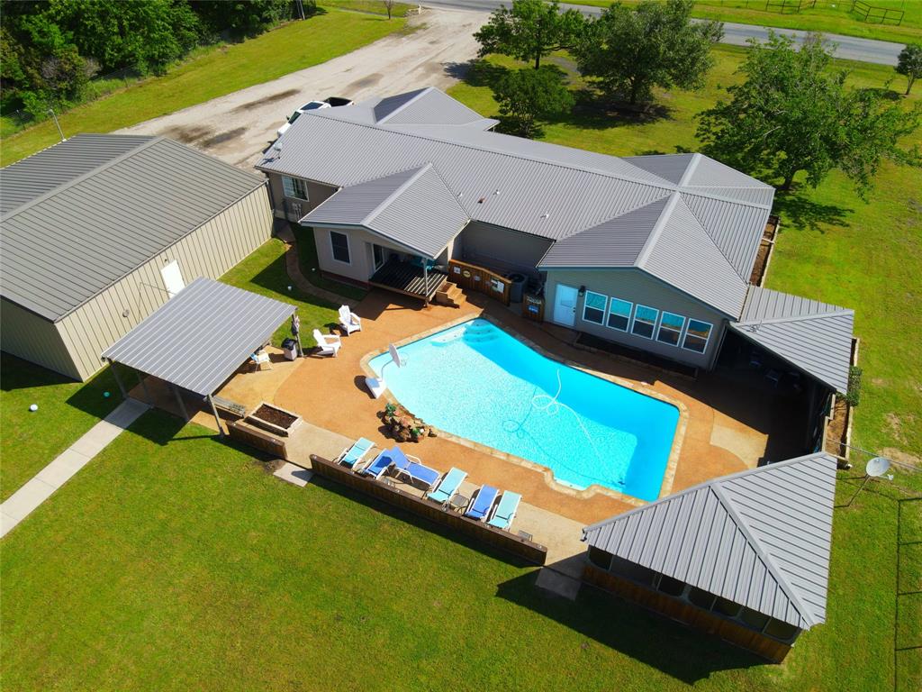 an aerial view of a house with backyard space and balcony